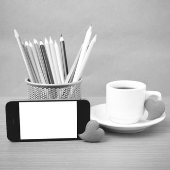 coffee,phone,color pencil and heart on wood table background black and white color