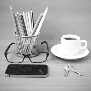 coffee,phone,eyeglasses,color pencil and key on wood table background black and white color