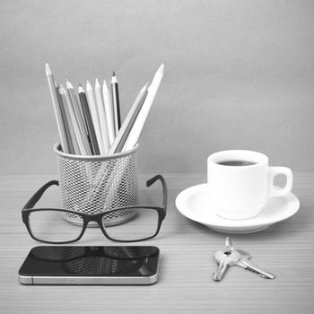 coffee,phone,eyeglasses,color pencil and key on wood table background black and white color