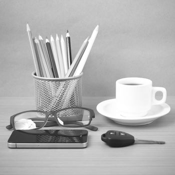 coffee,phone,eyeglasses,color pencil and car key on wood table background black and white color