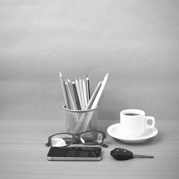 coffee,phone,eyeglasses,color pencil and car key on wood table background black and white color