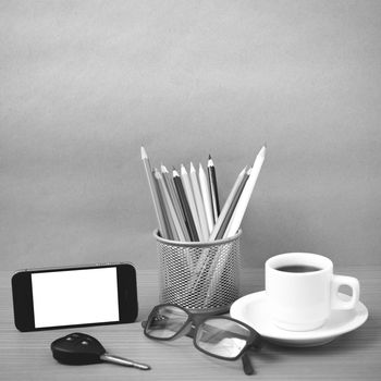 coffee,phone,eyeglasses,color pencil and car key on wood table background black and white color