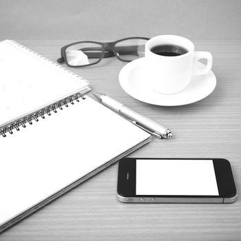 coffee,phone,eyeglasses,notepad and canlendar on wood table background black and white color