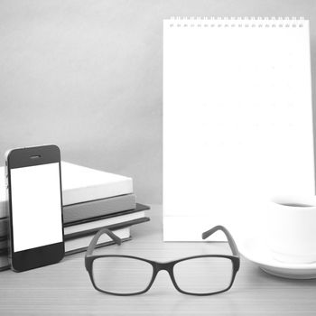 coffee,phone,eyeglasses,stack of book and calendar on wood table background black and white color