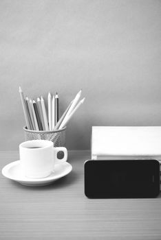 coffee,phone,stack of book and color pencil on wood table background black and white color