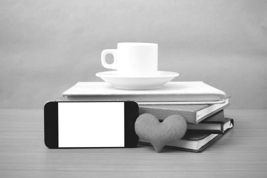 coffee,phone,stack of book and heart on wood table background black and white color