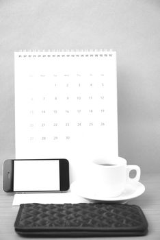 coffee,phone,wallet and canlendar on wood table background black and white color