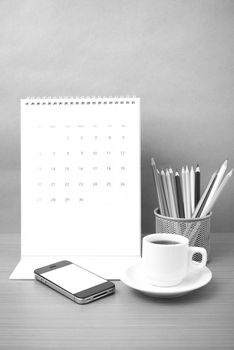 coffee,phone,calendar and color pencil on wood table background black and white color