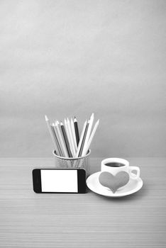 coffee,phone,color pencil and heart on wood table background black and white color