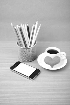 coffee,phone,color pencil and heart on wood table background black and white color