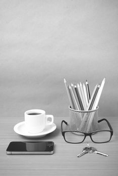 coffee,phone,eyeglasses,color pencil and key on wood table background black and white color