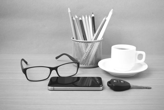 coffee,phone,eyeglasses,color pencil and car key on wood table background black and white color
