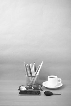 coffee,phone,eyeglasses,color pencil and car key on wood table background black and white color