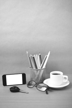 coffee,phone,eyeglasses,color pencil and car key on wood table background black and white color