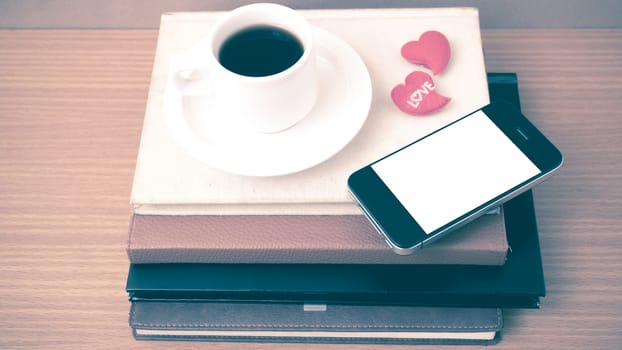 coffee,phone,stack of book and heart on wood table background vintage style