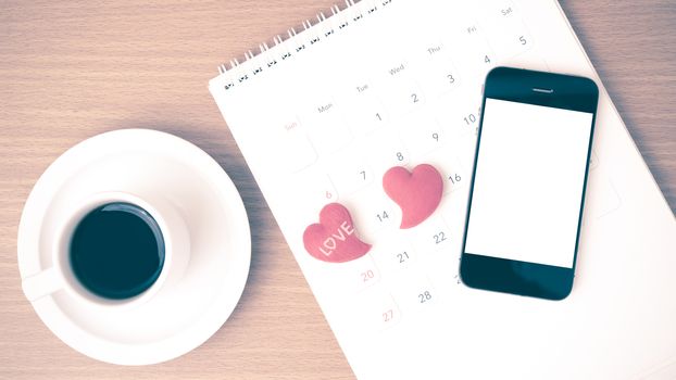 coffee,phone,calendar and heart on wood table background vintage style