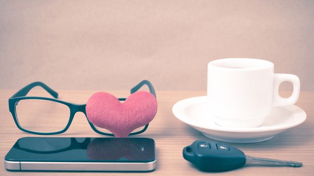 coffee,phone,eyeglasses and car key on wood table background vintage style