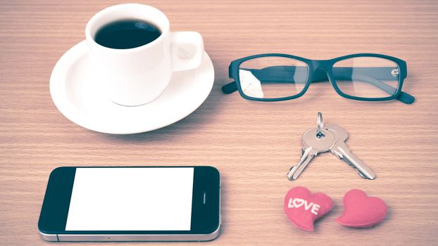 coffee,phone,eyeglasses and key on wood table background vintage style