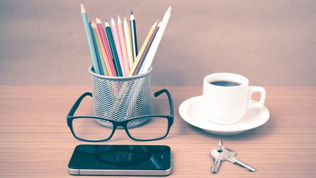 coffee,phone,eyeglasses,color pencil and key on wood table background vintage style