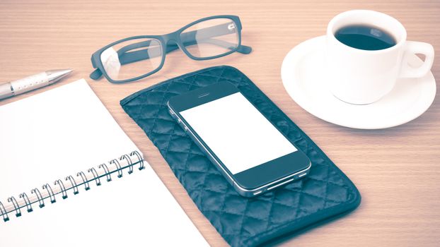 coffee,phone,eyeglasses,notepad and wallet on wood table background vintage style