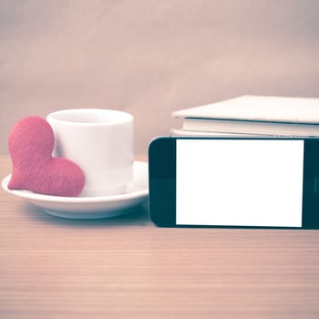 coffee,phone,stack of book and heart on wood table background vintage style