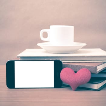 coffee,phone,stack of book and heart on wood table background vintage style