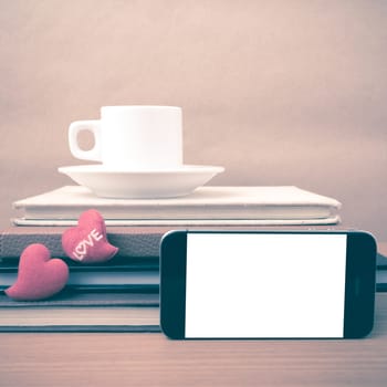 coffee,phone,stack of book and heart on wood table background vintage style