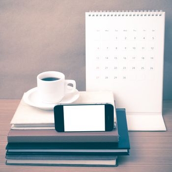 coffee,phone,stack of book and calendar on wood table background vintage style