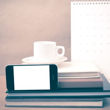 coffee,phone,stack of book and calendar on wood table background vintage style