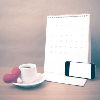 coffee,phone,calendar and heart on wood table background vintage style