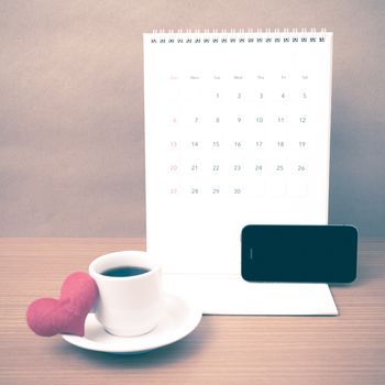 coffee,phone,calendar and heart on wood table background vintage style