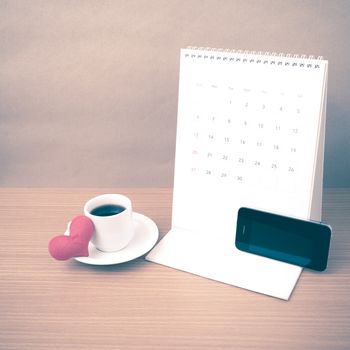 coffee,phone,calendar and heart on wood table background vintage style