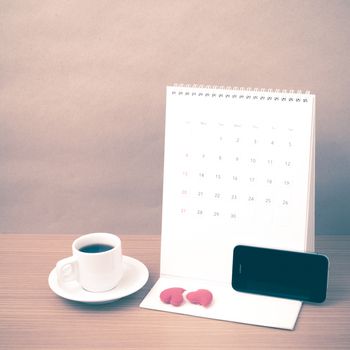 coffee,phone,calendar and heart on wood table background vintage style