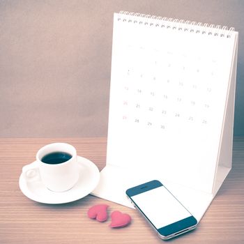 coffee,phone,calendar and heart on wood table background vintage style