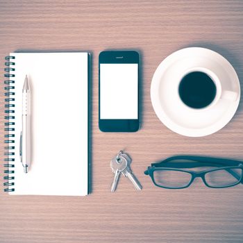 coffee,phone,notepad,eyeglasses and key on wood table background vintage style