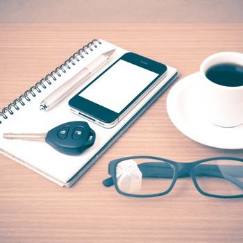 coffee,phone,notepad,eyeglasses and car key on wood table background vintage style