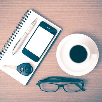 coffee,phone,notepad,eyeglasses and car key on wood table background vintage style