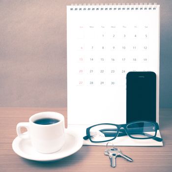 coffee,phone,eyeglasses,calendar and key on wood table background vintage style