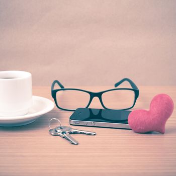 coffee,phone,eyeglasses and key on wood table background vintage style