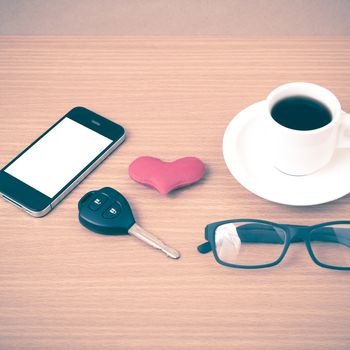 coffee,phone,eyeglasses and car key on wood table background vintage style