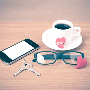 coffee,phone,eyeglasses and key on wood table background vintage style