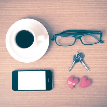 coffee,phone,eyeglasses and key on wood table background vintage style
