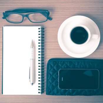 coffee,phone,eyeglasses,notepad and wallet on wood table background vintage style