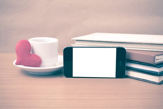 coffee,phone,stack of book and heart on wood table background vintage style