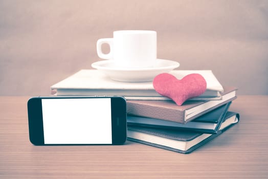 coffee,phone,stack of book and heart on wood table background vintage style