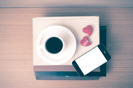 coffee,phone,stack of book and heart on wood table background vintage style