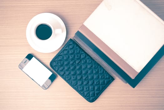 coffee,phone,stack of book and wallet on wood table background vintage style