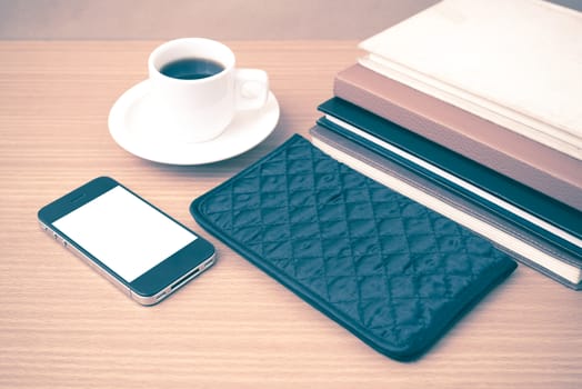 coffee,phone,stack of book and wallet on wood table background vintage style