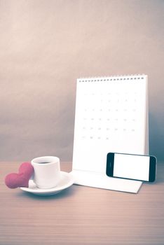 coffee,phone,calendar and heart on wood table background vintage style