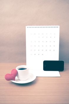 coffee,phone,calendar and heart on wood table background vintage style